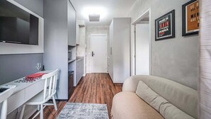 Un espacio habitable compacto con kitchenette, comedor y sofá.