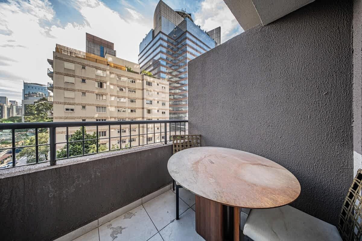 Un balcon avec une table ronde et une vue sur le paysage urbain.