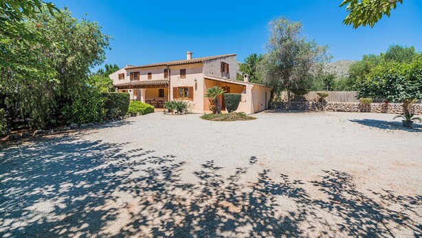 A two-story house with a gravel driveway and a small garden area. - Private Pool Villa in Pollensa (Pollença)