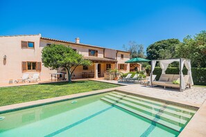 A pool area with a clear blue pool, lounge chairs, and a pergola with a canopy. - Private Pool Villa in Pollensa (Pollença)
