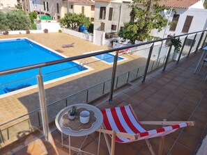 A balcony with a pool, a lounge chair, and a small table with a plant and a cup. - Apartment with AC, terrace - 6 guests (L'Escala)