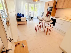 Una cucina moderna con zona pranzo, divano e balcone.
