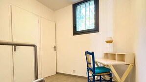 Une pièce avec un bureau, une chaise et une fenêtre.