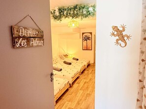 Ein Zimmer mit einem Bett, einem Wandschild und einem dekorativen Gegenstand.