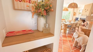 A dining area with a wooden table, chairs, and a hanging light fixture. - Villa, sea view, 14 guests (Le Lavandou)