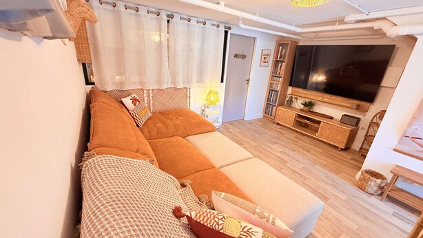 A modern living room with a sofa, a television, and a wooden floor. - Villa, sea view, 14 guests (Le Lavandou)