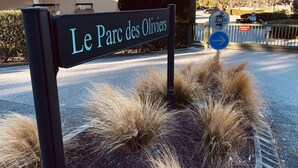 Schild für 'Le Parc des Oliviers' mit Pfeil und Verbotsschild.