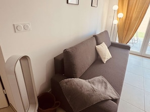 Ein modernes Wohnzimmer mit einer Couch, einem Couchtisch und einer Lampe.