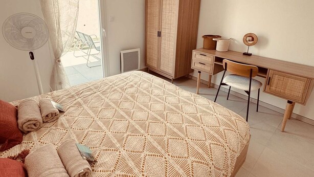 Ein Schlafzimmer mit Bett, Schreibtisch und Kleiderschrank.