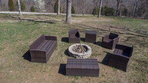 A fire pit surrounded by wicker furniture in an outdoor setting.