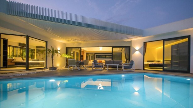 A modern outdoor pool area with a lounge, seating, and a view of the interior. - Wonderful 2-bedroom house with AC in charming Fethiye (fethiye)