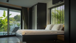 A modern bedroom with a large bed, a sliding glass door leading to a balcony, and a view of greenery. - Wonderful 2-bedroom house with AC in charming Fethiye (fethiye)