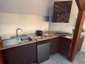 Eine kleine Küche mit Spüle, Toaster und einem kleinen Kühlschrank.