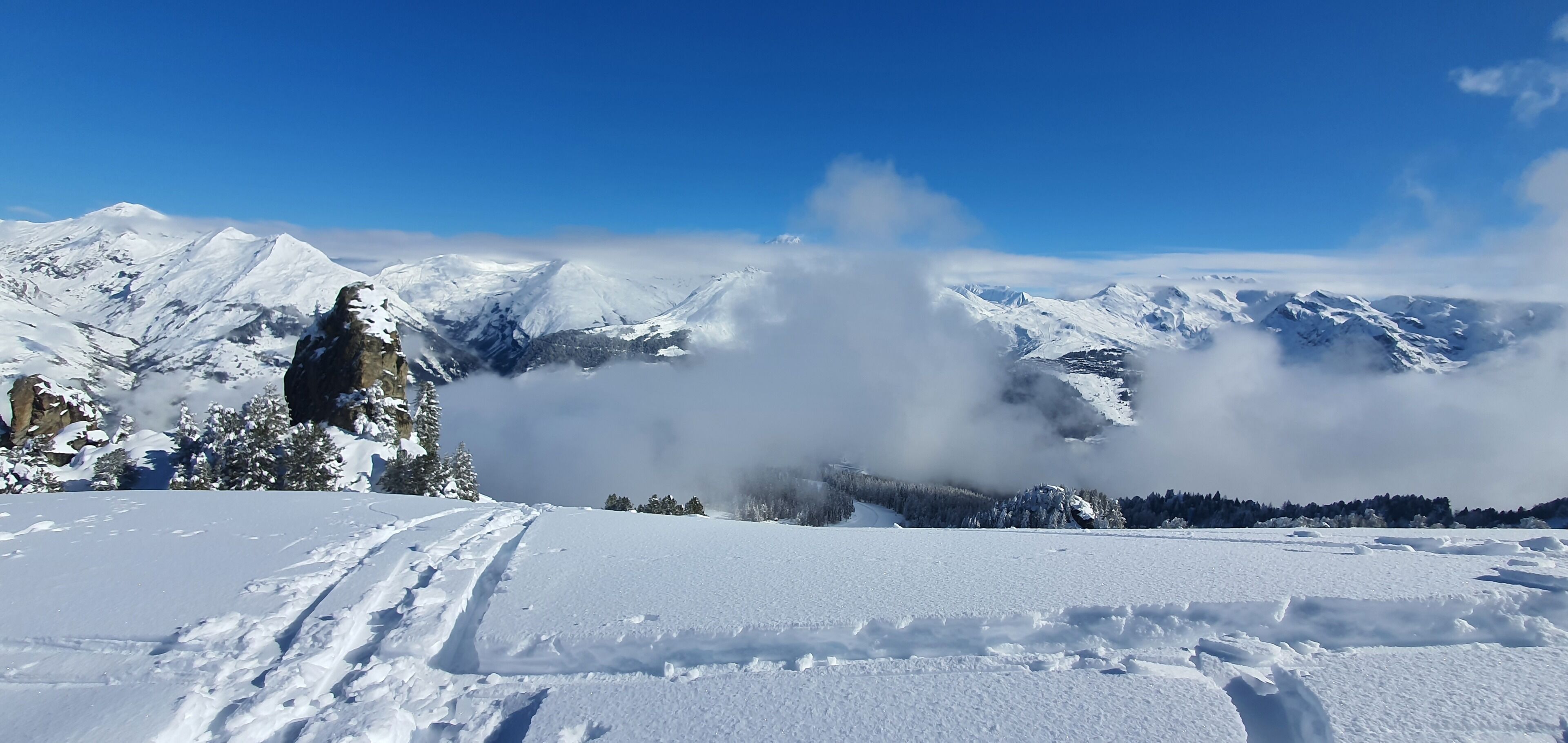 Eine verschneite Berglandschaft mit blauem Himmel.
