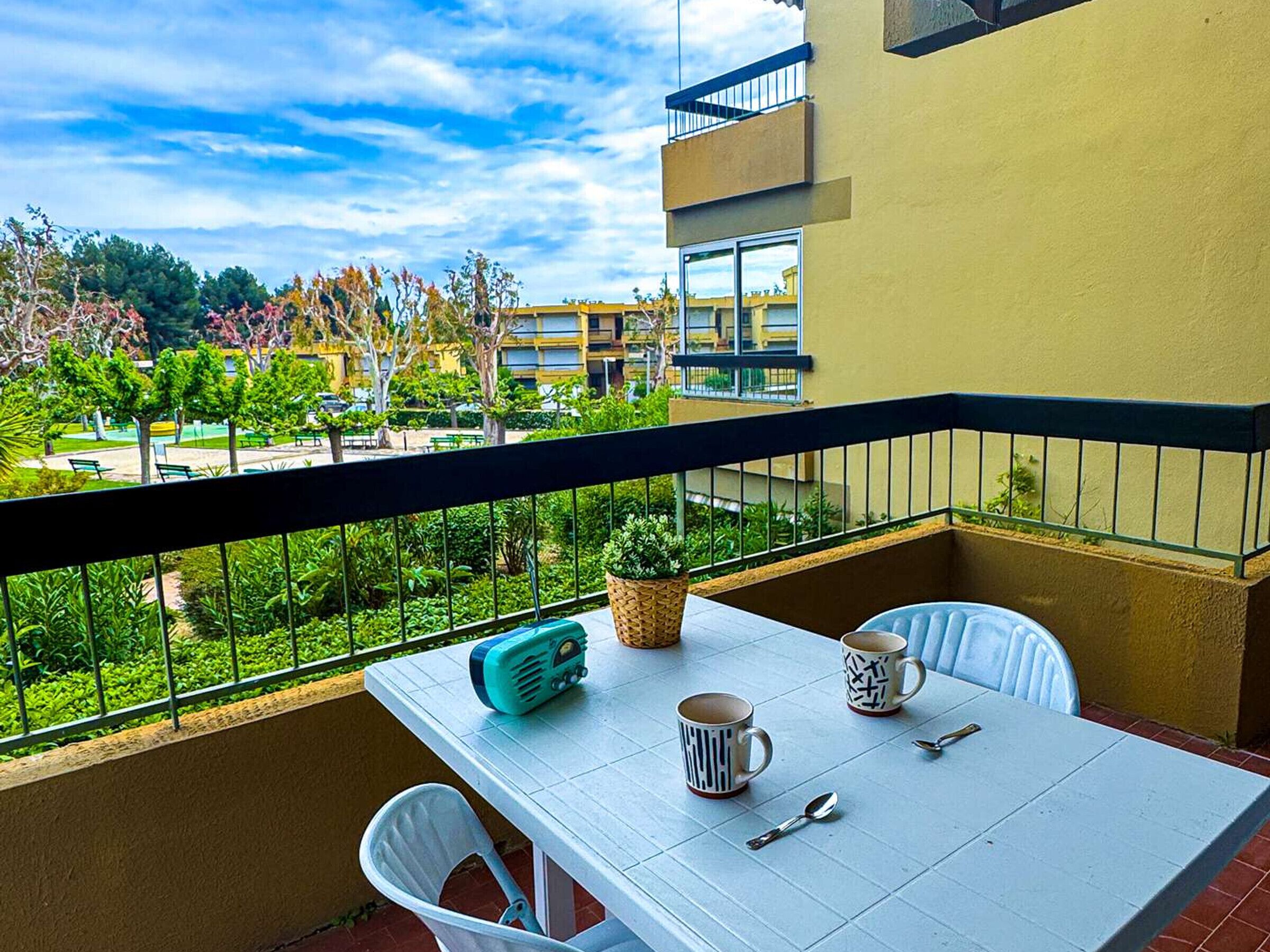 Ein Balkon mit Tisch, Stühlen und einem Radio.