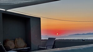 A poolside area with a chair and cushions, overlooking a sunset over the ocean. - Bevimar Lava Suite with Private Pool and Non Heated Jacuzzi (Finikia)