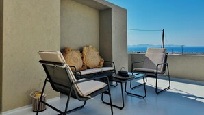 A rooftop terrace with two lounge chairs, a small table, and a view of the sea. - Bevimar Lava Suite with Private Pool and Non Heated Jacuzzi (Finikia)