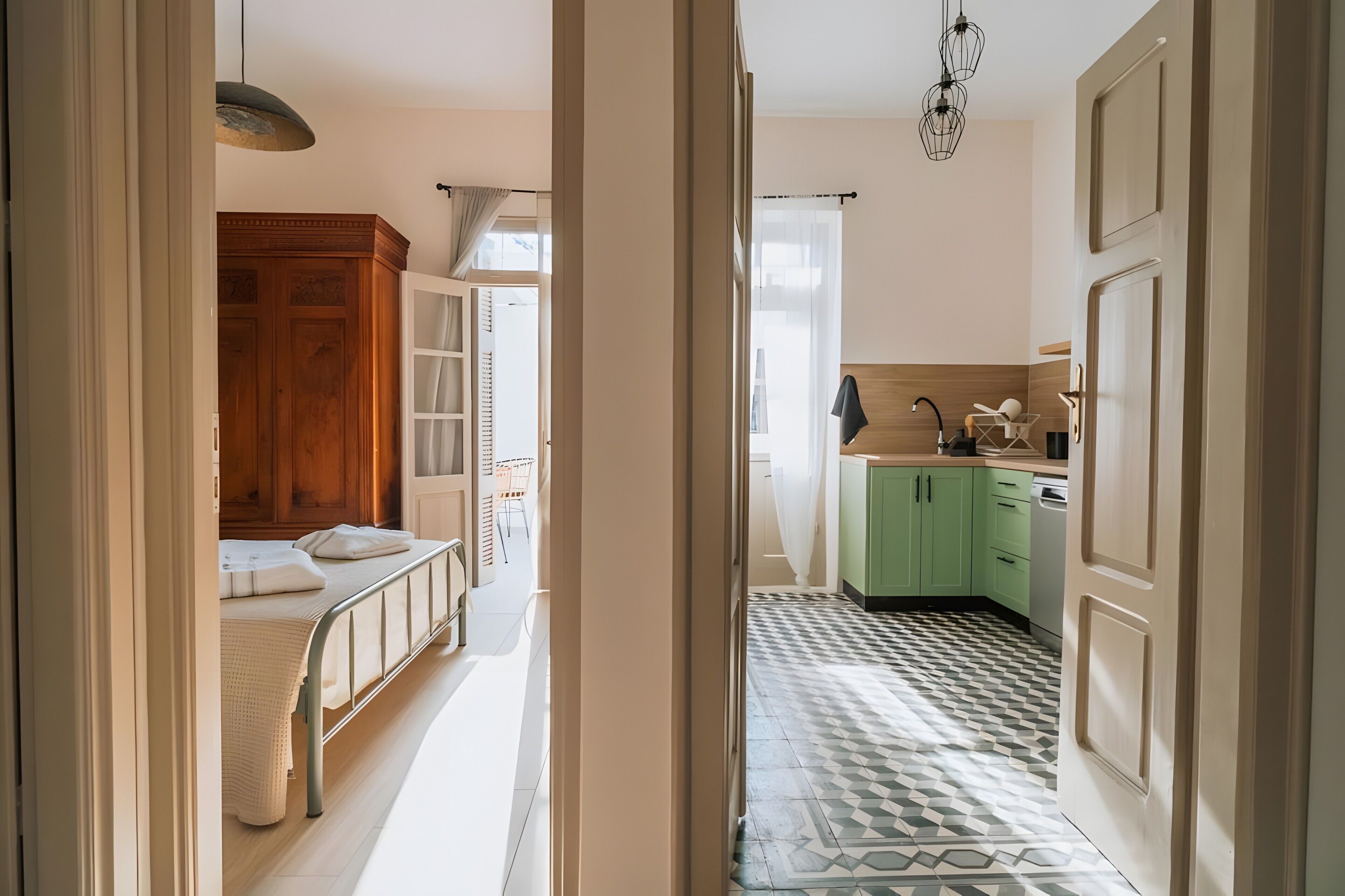 Un couloir étroit mène à une chambre comprenant un lit, une armoire et une salle de bain avec un lavabo et un miroir.