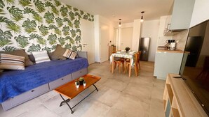 Ein gemütlicher Wohnbereich mit Sofa, Esstisch und Küchenzeile.