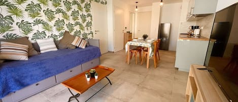 Ein gemütlicher Wohnbereich mit Sofa, Esstisch und Küchenzeile.