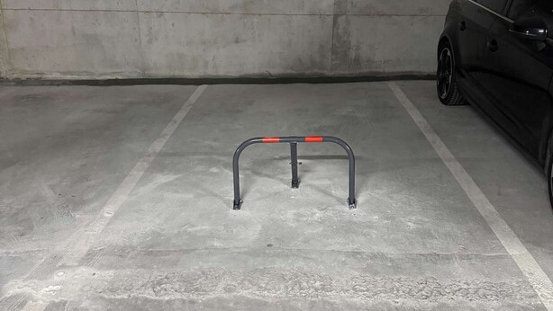 Eine Parkgarage mit Betonboden und Metallschranke.