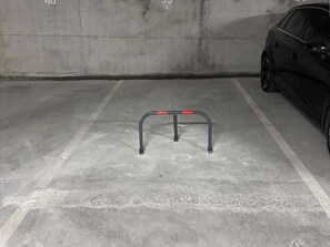 A parking garage with a concrete floor and a metal barrier. - Apartment, air conditioning, parking - 4 guests (Le Lavandou)