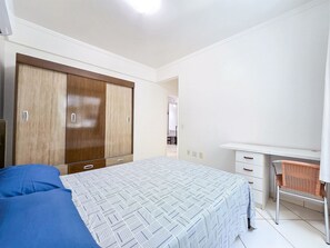 Une chambre à coucher avec un lit, une armoire, un bureau et une chaise.