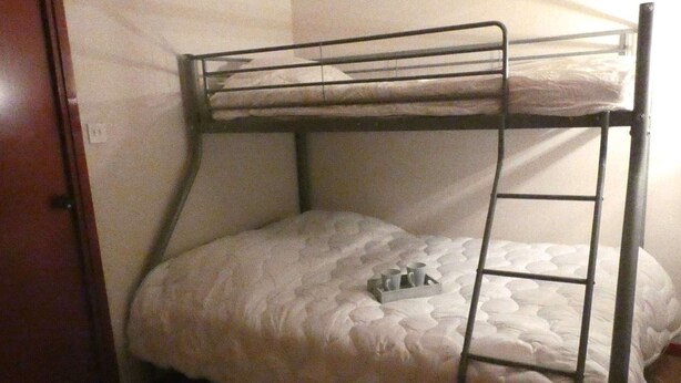 A bunk bed with a ladder, a tray with cups, and a door to the left. - Cozy apartment facing south - 4 guests (Saint-Lary-Soulan)