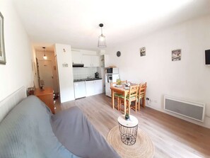 Ein gemütlicher, kompakter Wohnbereich mit Küchenzeile, Essplatz und einer Couch.