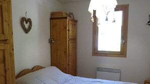 Une chambre avec un grand lit, une armoire en bois et une fenêtre donnant sur un beau paysage.