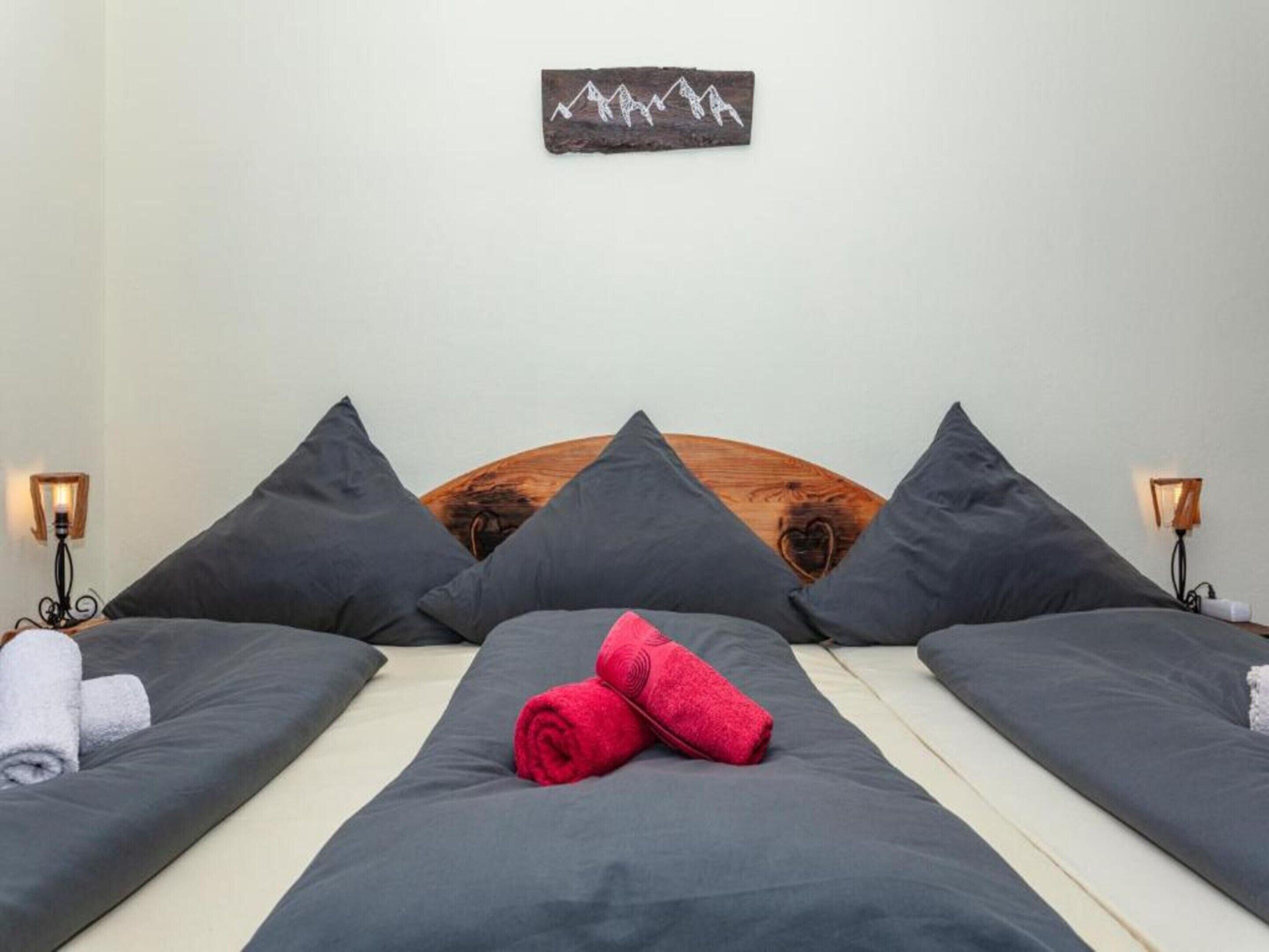 Una camera d'hotel con un letto, due comodini e un'opera d'arte appesa al muro.