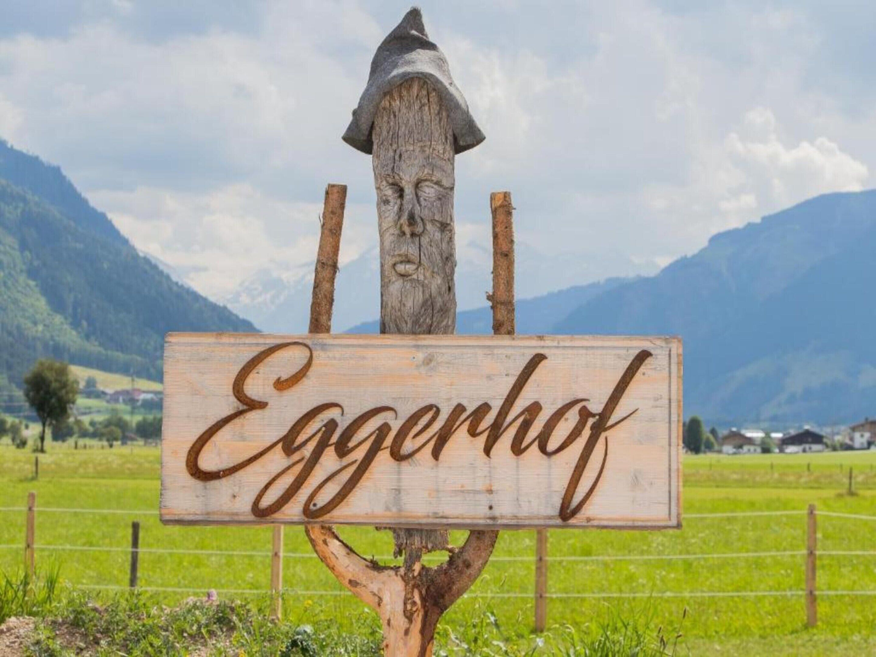 A wooden sign with the name 'Eggerhof' mounted on a tree.