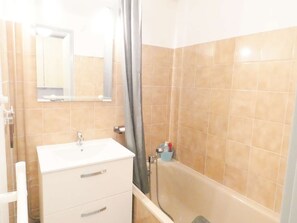 Ein Badezimmer mit Waschbecken, Spiegel und Duschbereich.