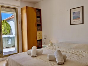A hotel room with a bed, a wardrobe, a bedside table with a lamp, and a framed picture on the wall. - Apartment with jacuzzi - 6 guests (Tossa de Mar)