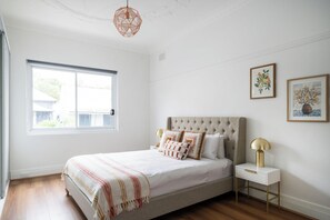 A bedroom with a bed, a nightstand, a lamp, and two framed pictures on the wall. - 5 Springside Rozelle (Rozelle)
