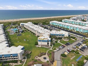 A coastal hotel with multiple buildings, a parking lot, and a beach in the background. - Seagull Haven, A Place at the Beach Resort! (Atlantic Beach)