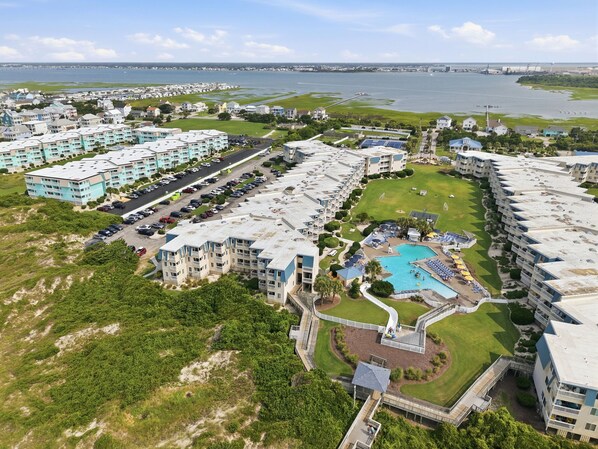 A large hotel complex with multiple buildings, a swimming pool, and a parking lot. - Seagull Haven, A Place at the Beach Resort! (Atlantic Beach)