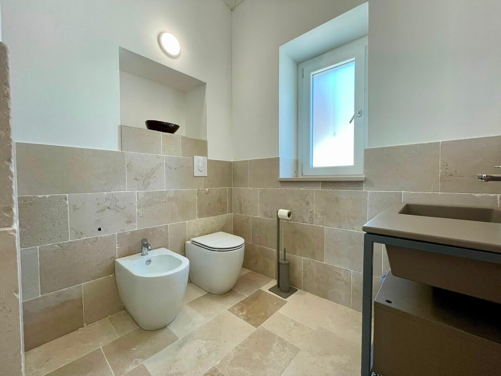 Ein modernes Badezimmer mit integriertem Bidet, Toilette und Waschbecken.