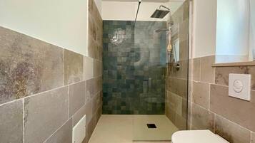 Ein Badezimmer mit einer Duschkabine, einer Toilette und einem Waschbecken.