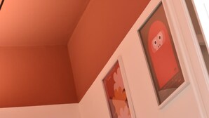 Une pièce avec un plafond en pente et un tableau encadré accroché au mur.