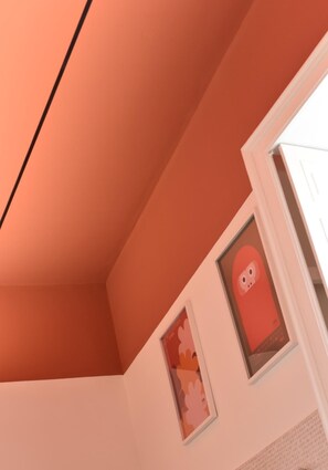 Ein Zimmer mit schrägem Dach und einem gerahmten Bild an der Wand.