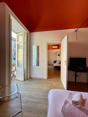 Ein Hotelzimmer mit Bett, Fernseher und Blick auf den Balkon.