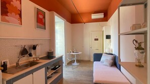 Un espace de vie compact comprenant un coin cuisine, un coin repas et un canapé.