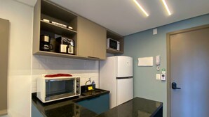 Une cuisine compacte équipée d’un four à micro-ondes, d’un four et d’un réfrigérateur.