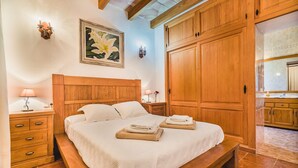 A bedroom with a wooden bed, a nightstand, a painting, and a wardrobe. - Contemporary Mallorcan Villa for 6 (Pollença)