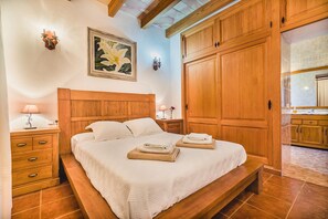 A bedroom with a wooden bed, a nightstand, a painting, and a wardrobe. - Contemporary Mallorcan Villa for 6 (Pollença)