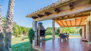 An outdoor patio with a barbecue grill, seating area, and a view of a swimming pool. - Contemporary Mallorcan Villa for 6 (Pollença)