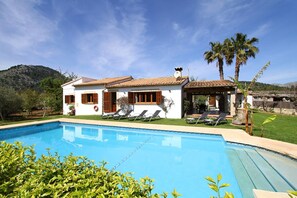 A two-story house with a swimming pool, a covered patio, and a mountain backdrop. - Contemporary Mallorcan Villa for 6 (Pollença)