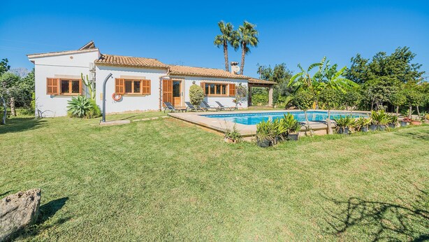 A two-story house with a swimming pool, surrounded by a well-maintained lawn and tropical plants. - Contemporary Mallorcan Villa for 6 (Pollença)