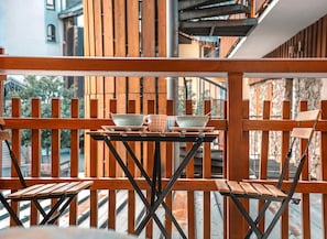 A wooden deck with a table set for two, featuring a bowl and a cup. - Le Bel Alp - The Perfect Mountain Getaway (Les Deux Alpes)